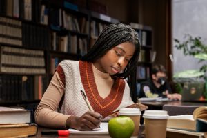 Child reviewing a mid-term report, looking determined to improve mid-term grades.